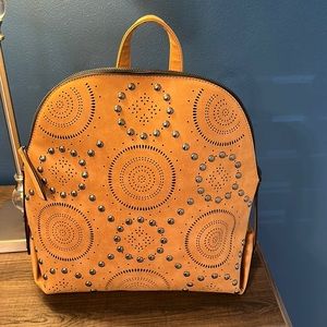 Tan backpack with studs. New. Has an inside zipper and 2 pockets on the inside.